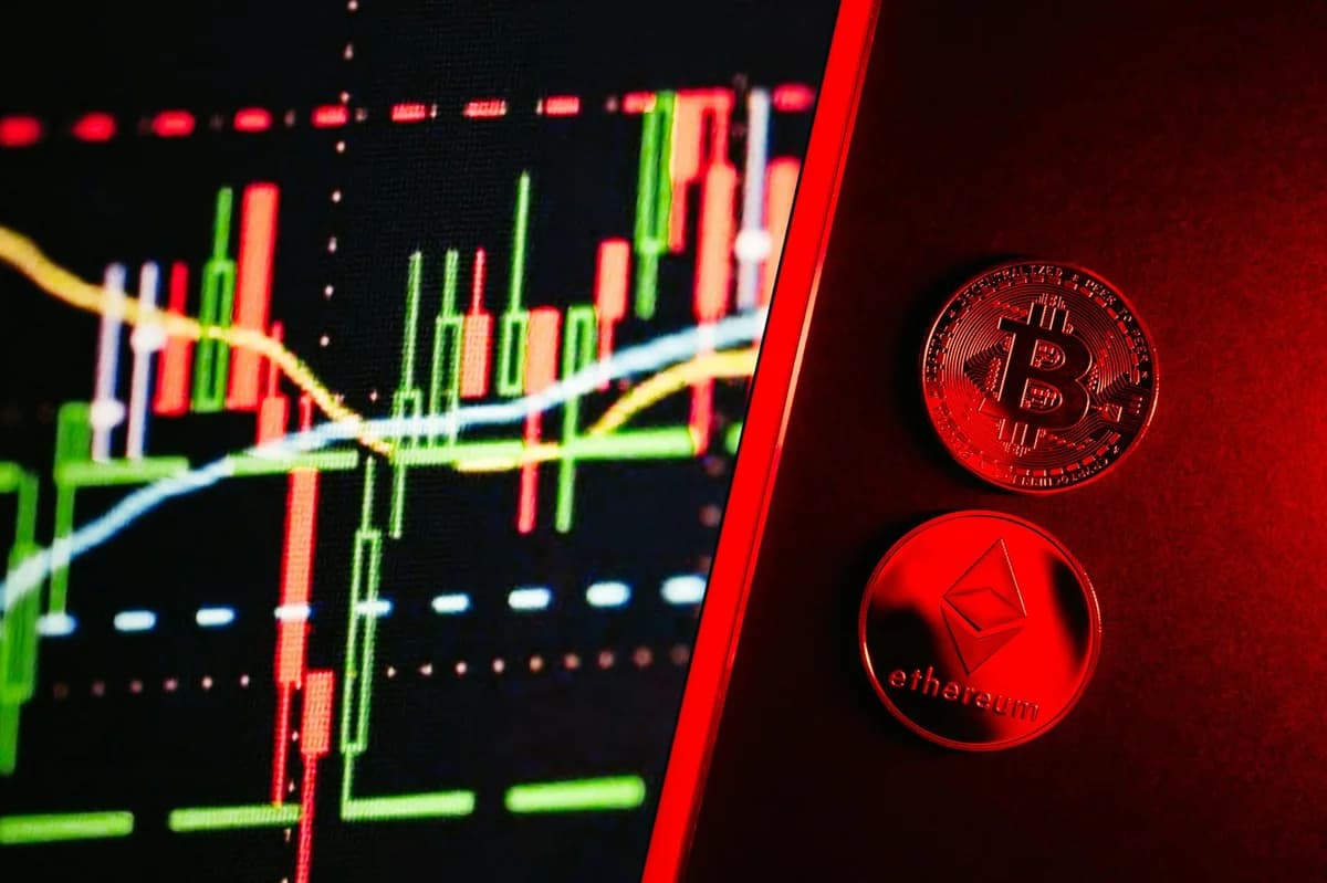 Close-up of a laptop displaying stock market graphs with a paper on investing in cryptocurrency, indoors.