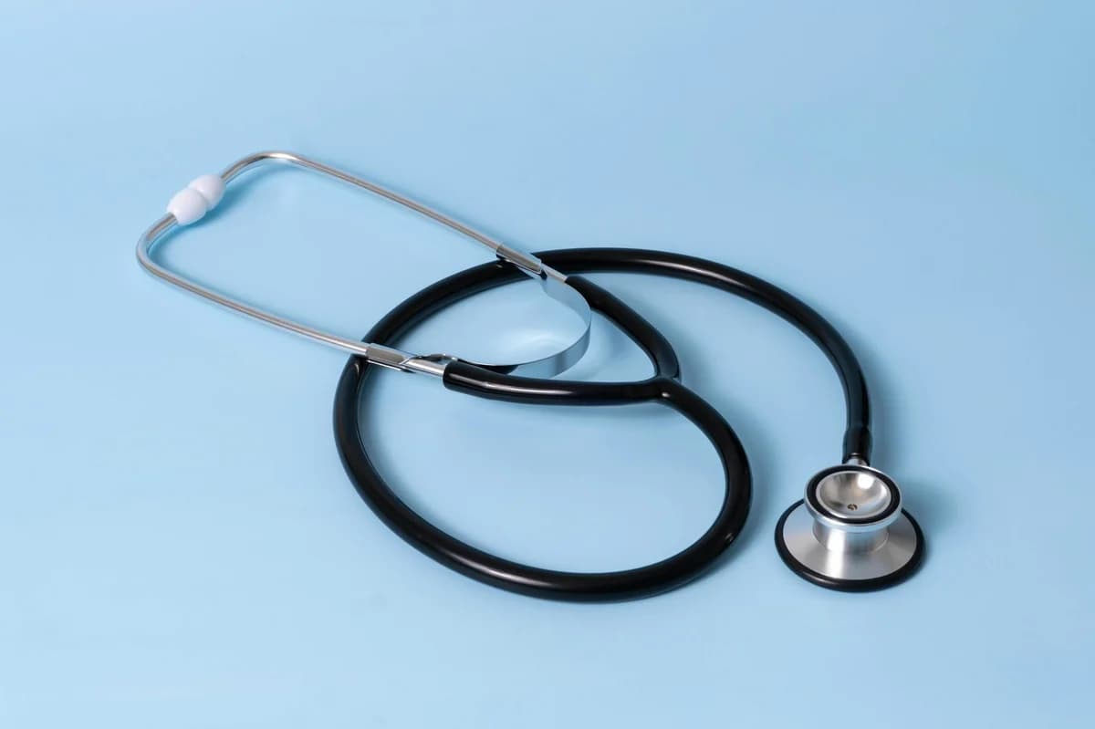 Close-up of a classic stethoscope on a blue background, symbolizing healthcare and medical profession.