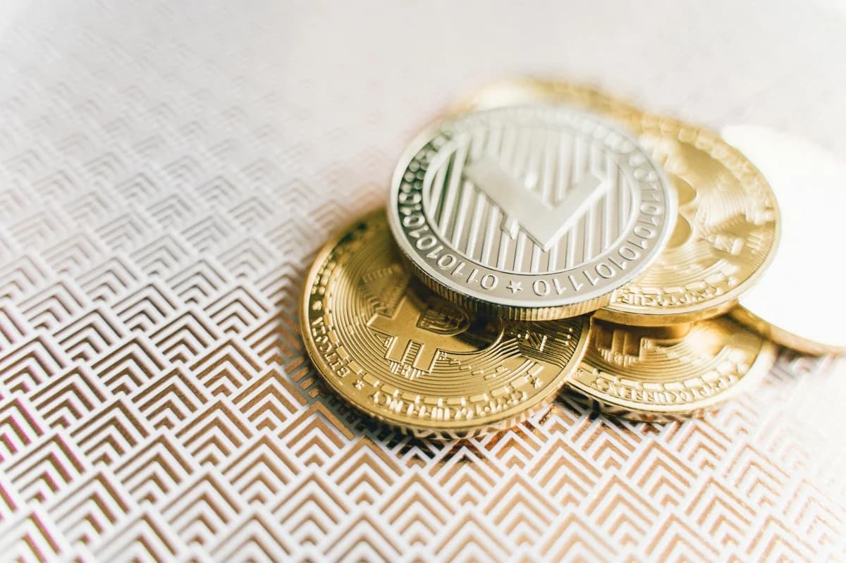 A collection of digital cryptocurrency coins, including Bitcoin and Ethereum, arranged on a stylish gold backdrop.