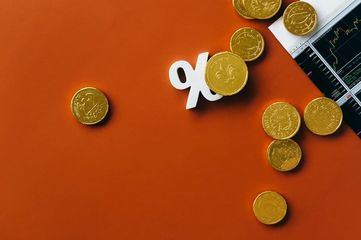 Stacked coins and a classic alarm clock symbolize the value of time and money.