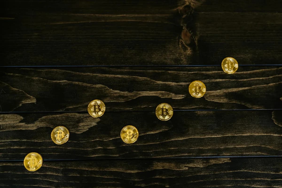 Close-up of bitcoins on a shimmering gold background, symbolizing digital wealth and investment.