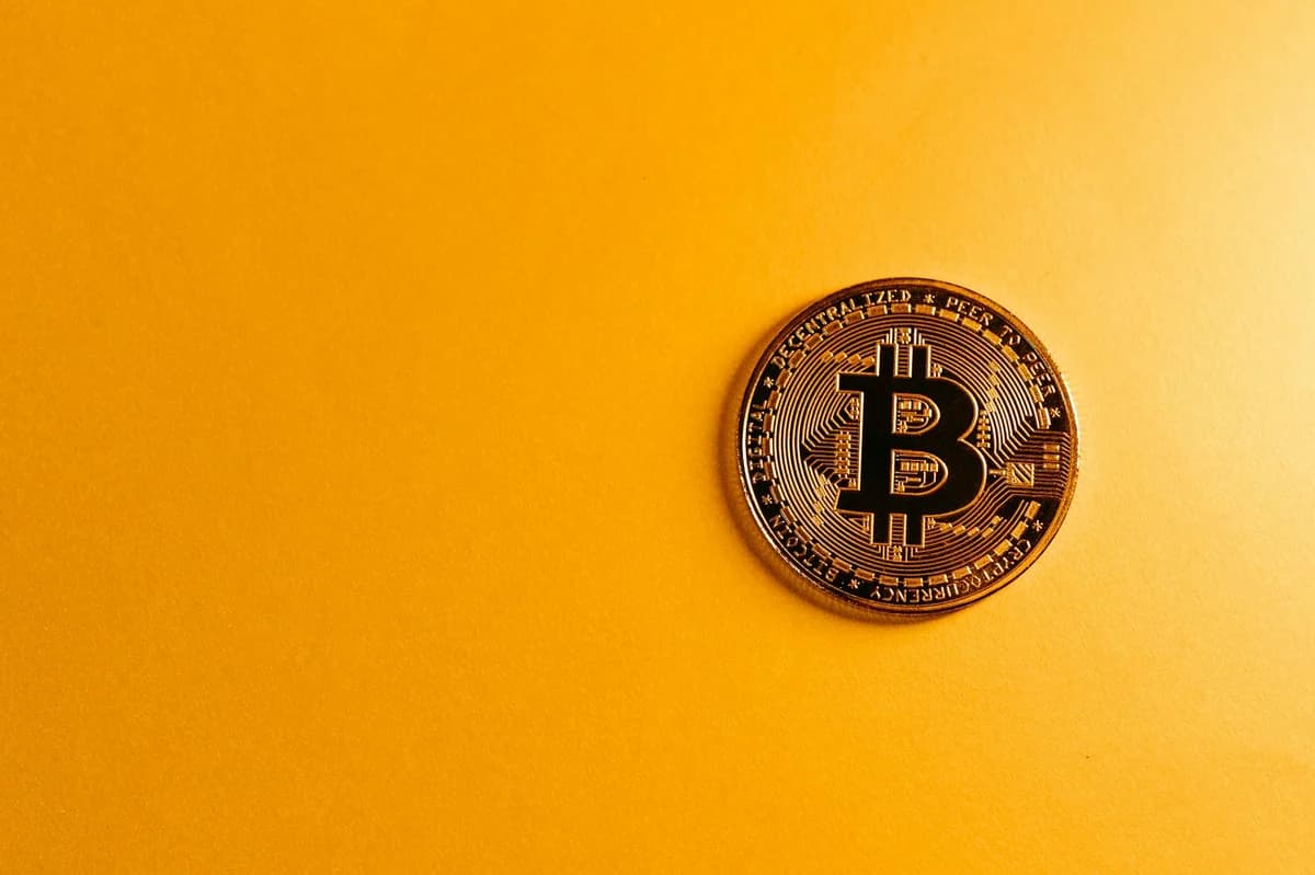 Close-up of golden Bitcoin coins on a sleek black background, emphasizing cryptocurrency themes.