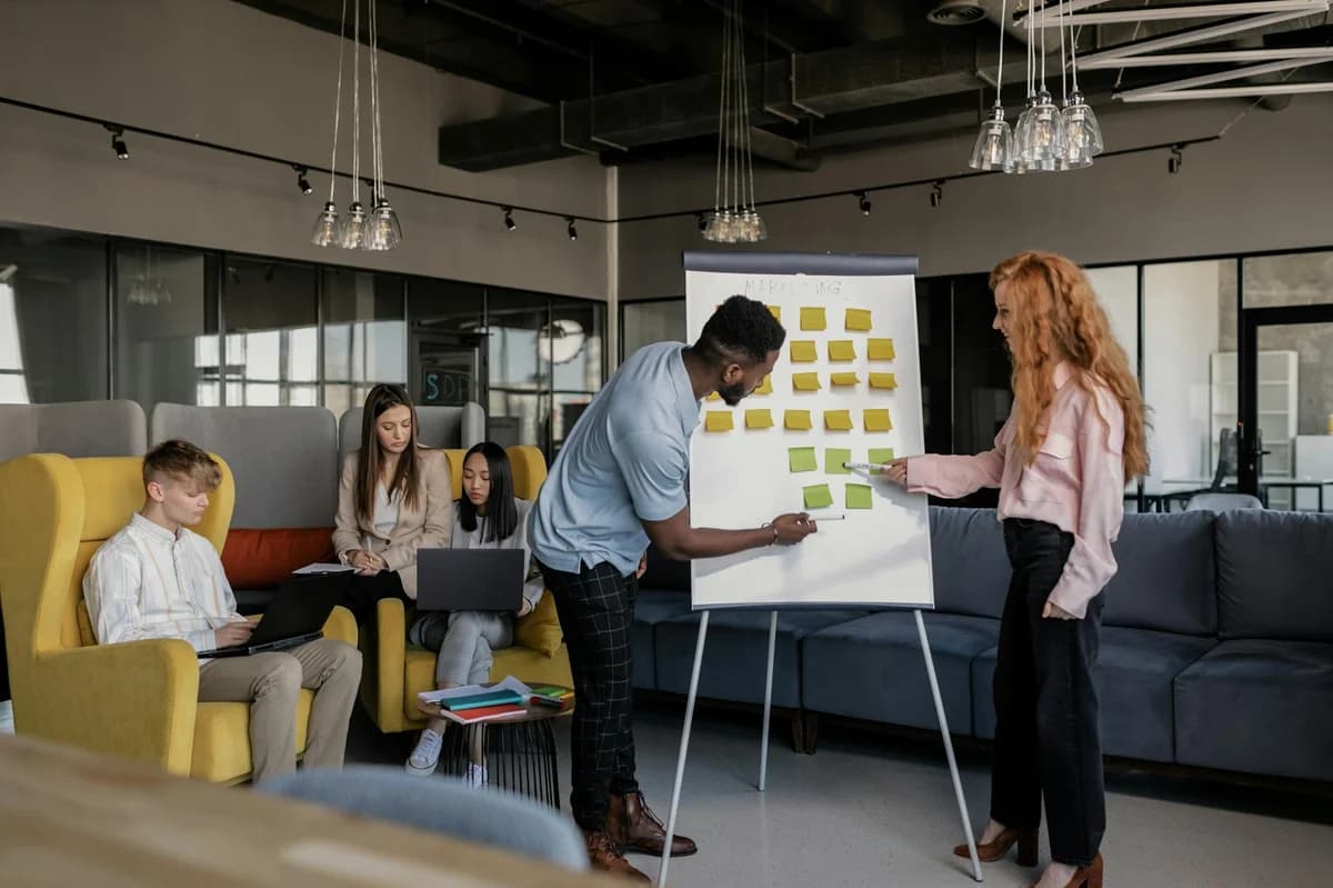 A diverse group of professionals collaborating with sticky notes in a modern office environment.