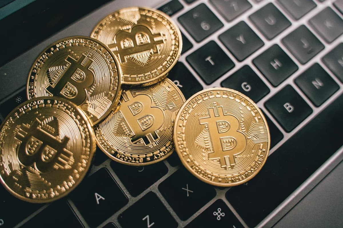 Close-up image showing hands exchanging a Bitcoin coin, symbolizing cryptocurrency transactions.