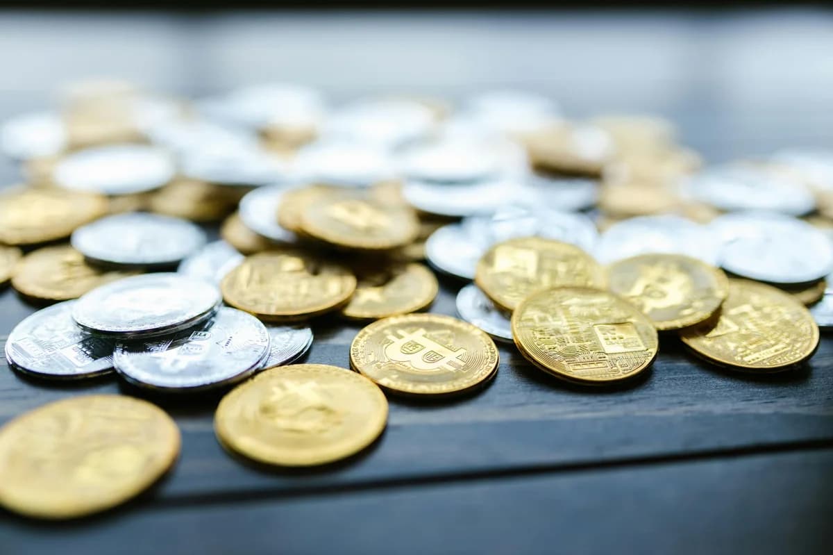 A detailed view of various cryptocurrency coins scattered on a wooden surface.