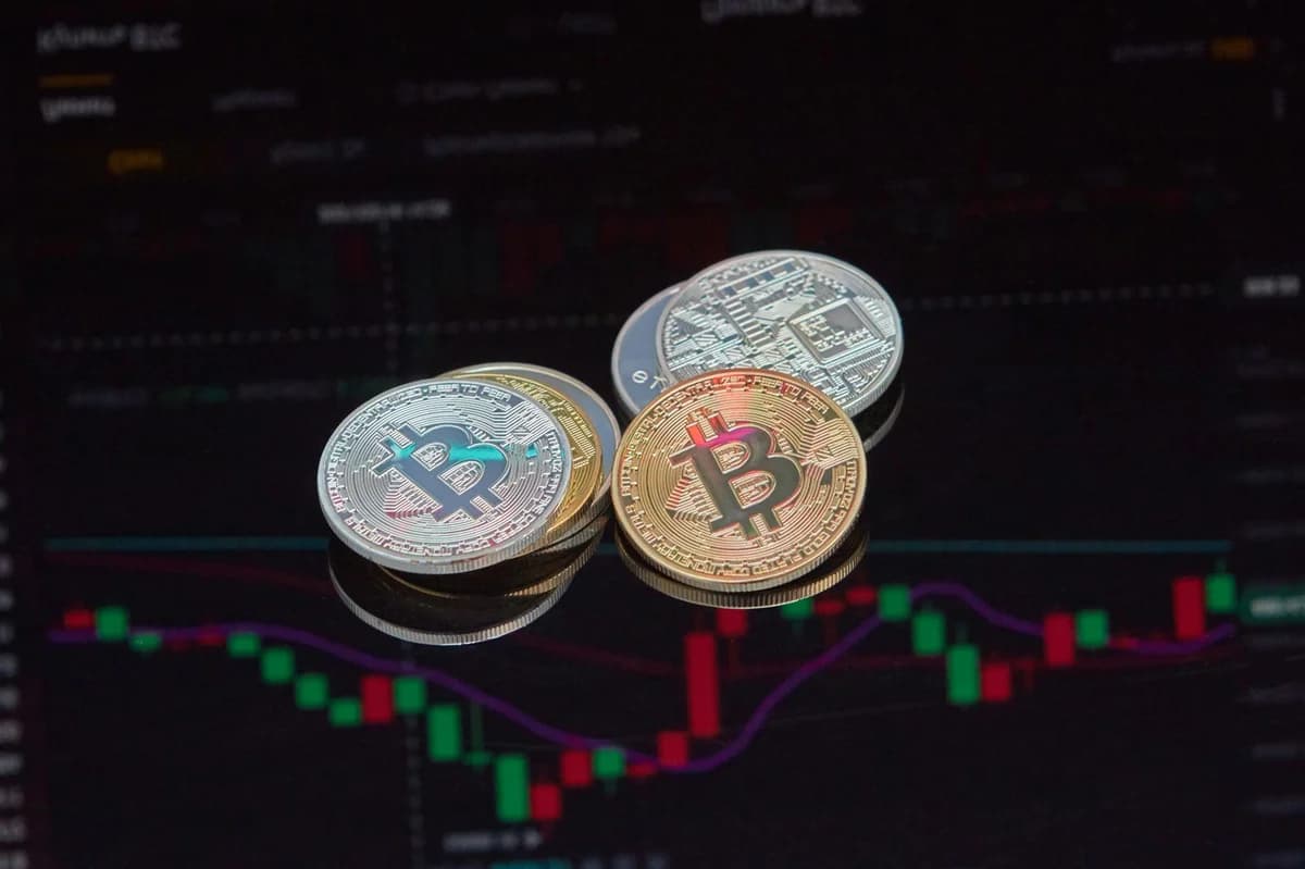 Crypto Basics: BTC vs ETH, CEX vs DEX, Hot vs Cold Close-up view of Bitcoin coins on a stock market chart background representing cryptocurrency trading.