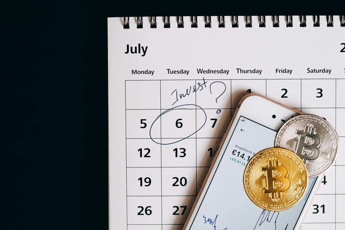 How Interest Rate Decisions Affect Crypto Markets Gold and silver cryptocurrency coins scattered on a trading chart over a wooden table.