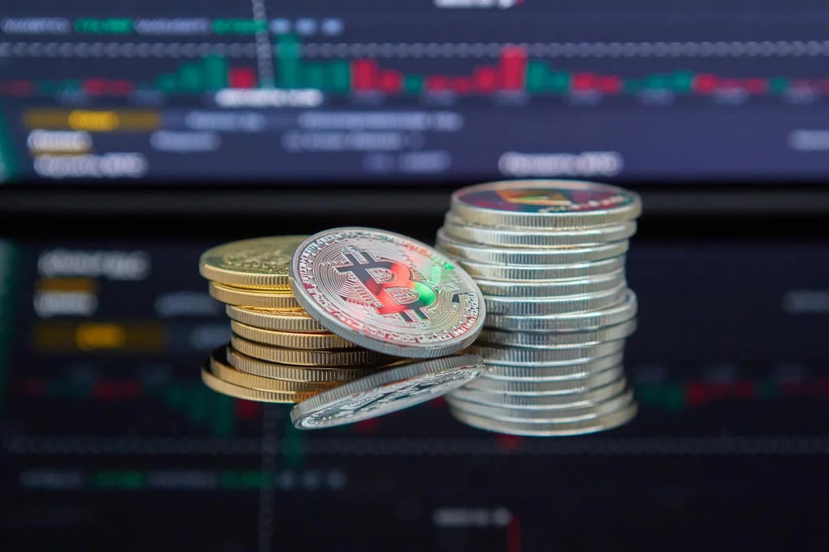 What Is a Basis Trade in Crypto? Close-up of cryptocurrency coins with a market graph background.