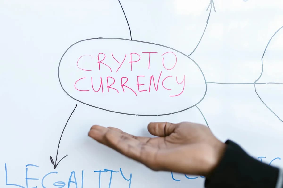 What Is a Basis Trade in Crypto? Close-up of a hand gesturing at a cryptocurrency diagram on a whiteboard, highlighting crypto concepts.
